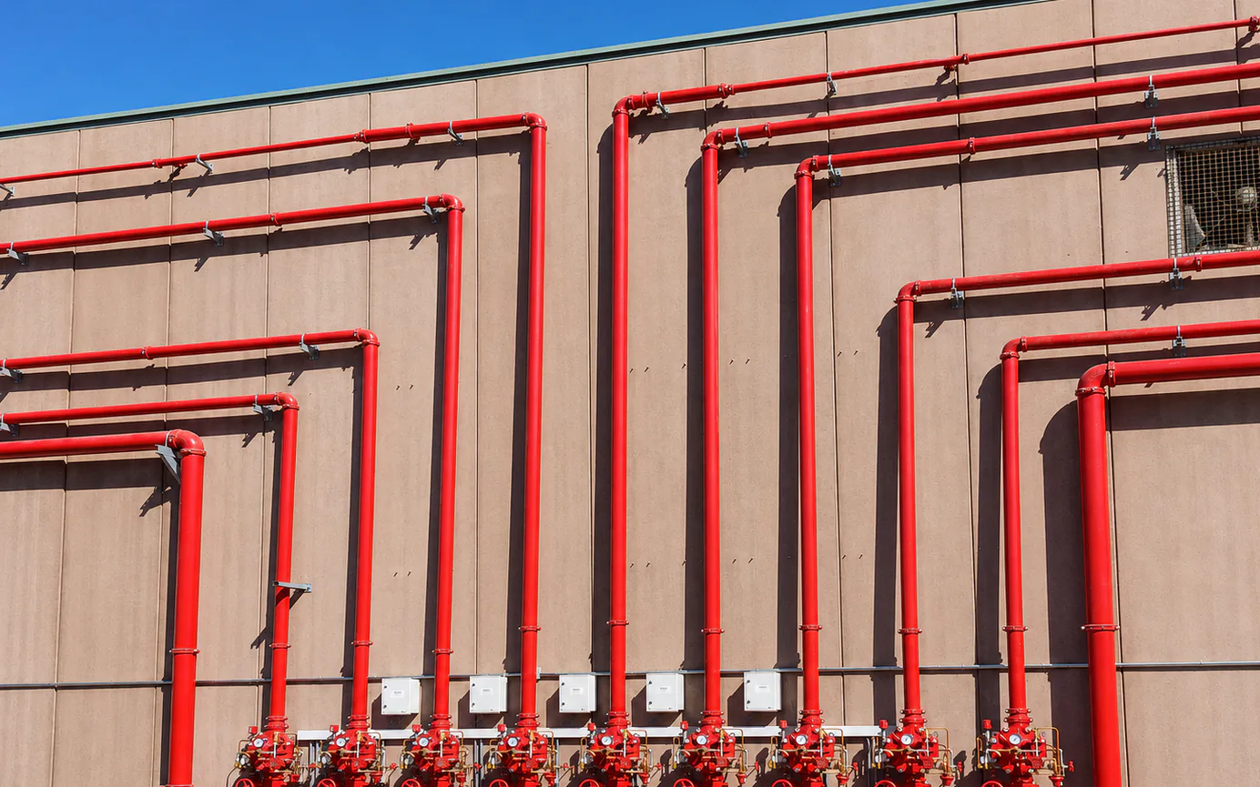 Red pipes with valves, supports, and gauges.